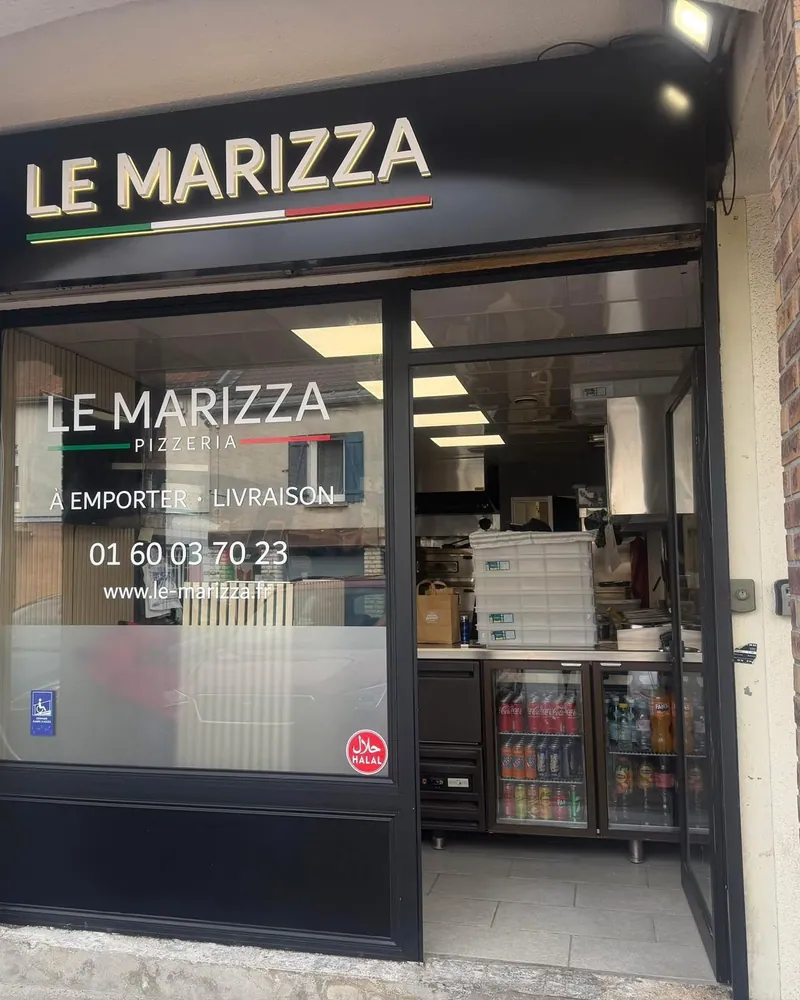 Devanture de la pizzeria Le Marizza à Saint-Mard : enseigne noire, vitrine « À emporter · Livraison » et comptoir